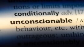 Dictionary page with the word unconscionable being lit up