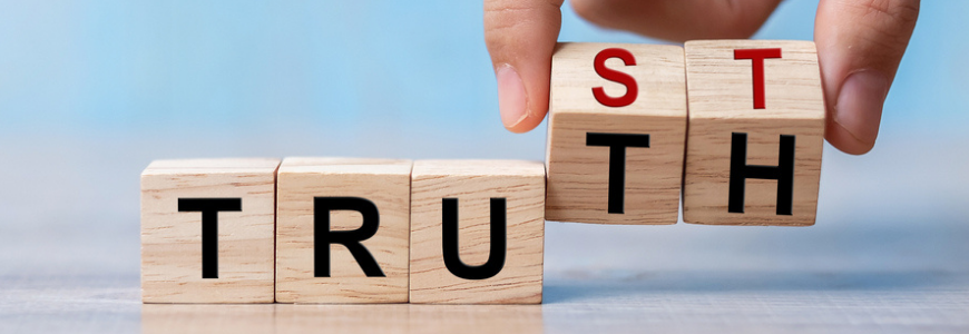 Businessman hand change wooden cube block with TRUST and TRUTH business word on table background