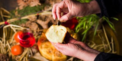 A hand pulling a coin out of a baked good