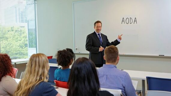 Lawyer standing in front of a whiteboard delivering training to a group