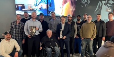 A sports team holding a medal cup after the game