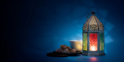 Low light photo of Lantern, Dates fruit and rosary for Ramadan and Eid greeting.