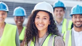 On site, on demand. Cropped shot of a female construction worker standing outside on a building site with her colleagues.