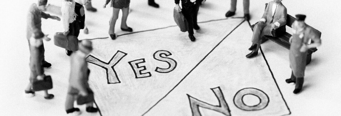 Toy figurines placed around a handwritten sign saying yes/no