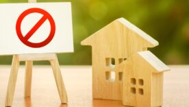 Wooden houses and an easel with a red prohibition sign NO.