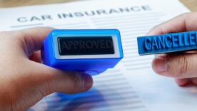 Businesswoman holding approved and cancelled rubber stamp to make a decision on car insurance