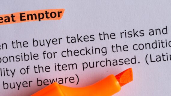 Caveat emptor word highlighted on the white paper