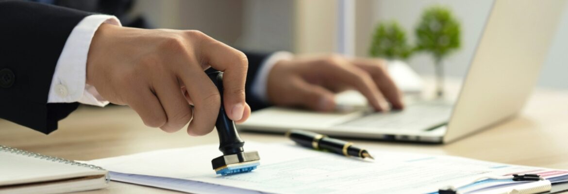 Businessman Hand Stamping With Approved Stamp On Document At Desk. validates and manages business documents and agreements.