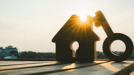 House model and hole key on wood table. Real estate agent offer house, property insurance and security, affordable housing concepts.