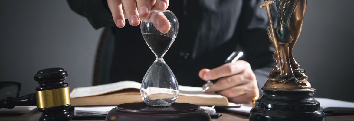 Judge's hand showing hourglass in a courtroom.